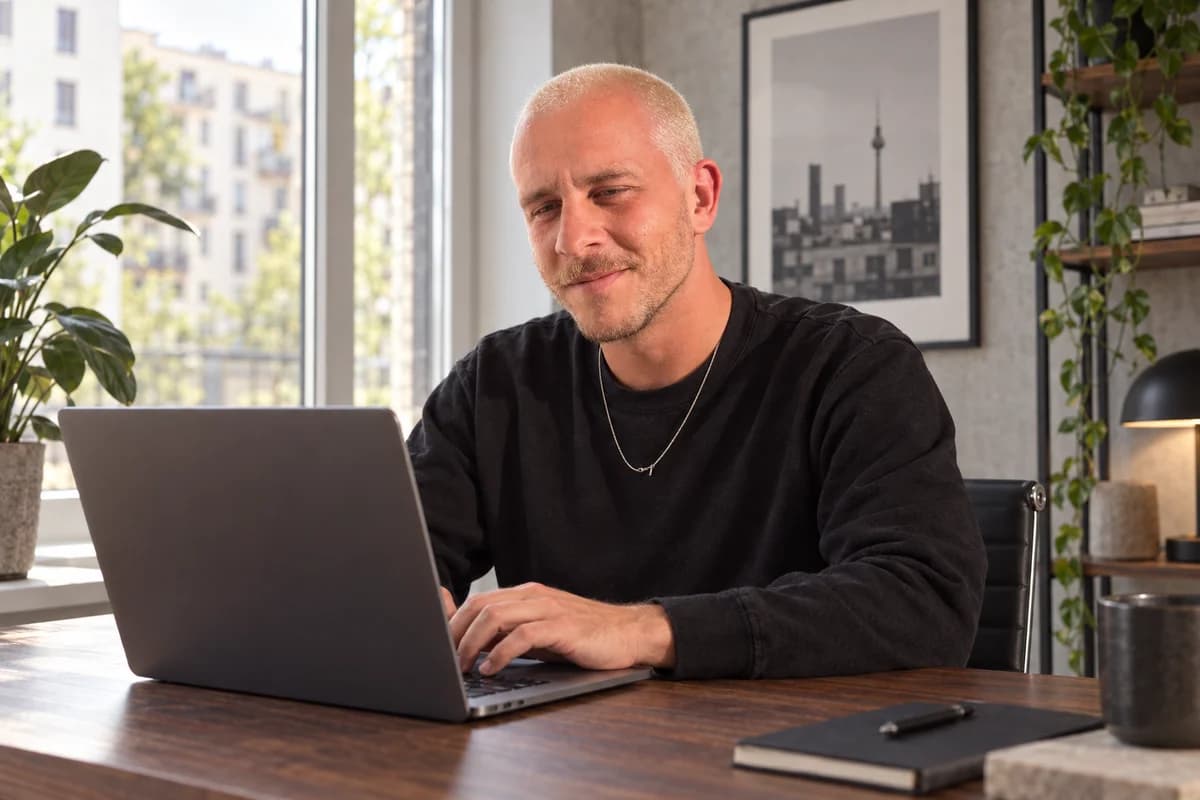 KI-generierte Szene: Sascha Hoffmann am Laptop.